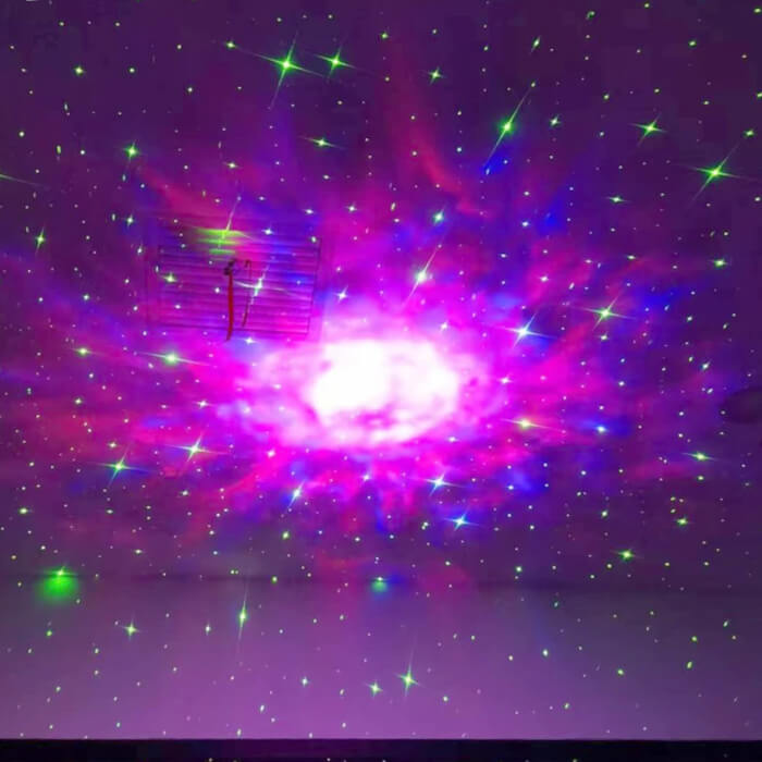 Galaxie rose au plafond avec le projecteur astronaute